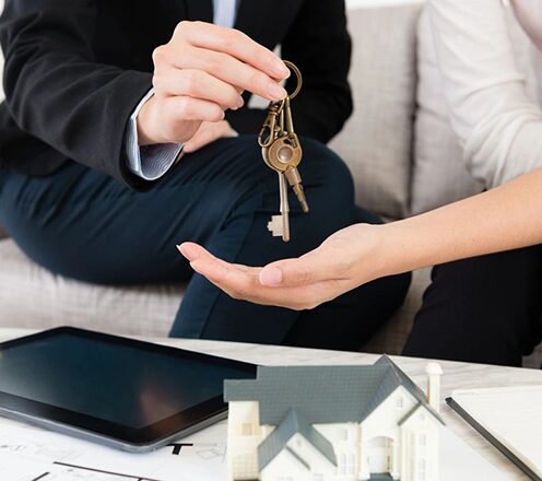 A man and woman holding keys to their new home.